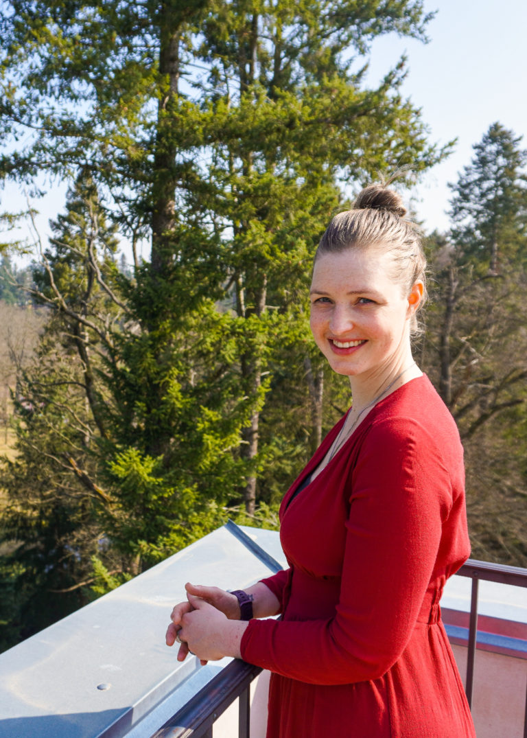 Marijke den Baas standing on a small tower in a forest, smiling